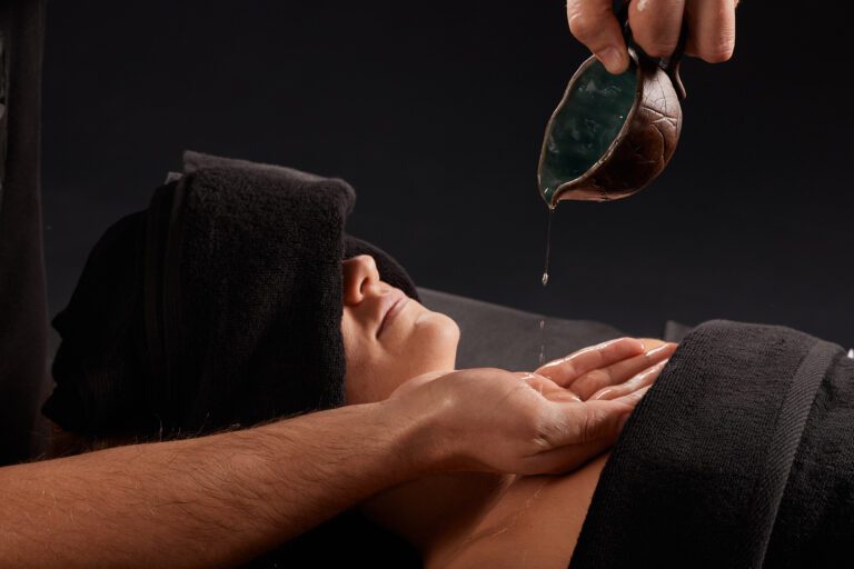 A professional massage therapist or massage therapist wraps a towel around a client's neck, performing a neck stretch. the client lies on the massage table covered with a towel