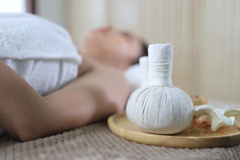 Beautiful young woman in spa salon. Beautiful spa composition on massage table in wellness center on the background of woman receiving treatment, Place for relaxation in modern wellness center.