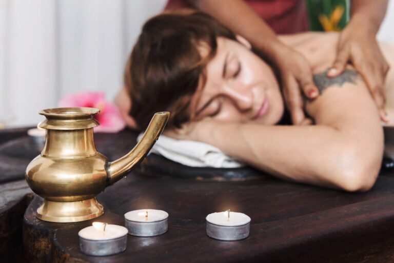 Caucasian woman having Ayurveda treatment in India. Kerala. Oil body massage, Asian spa accessories and candles .