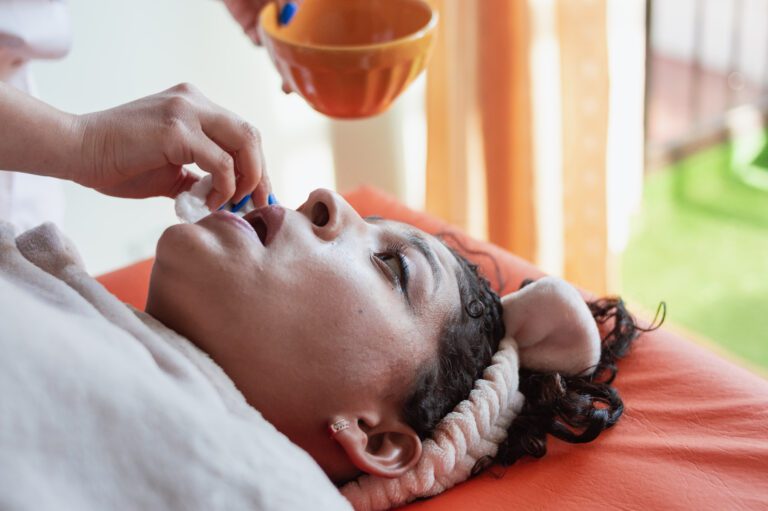 close-up of the face of one Hispanic Latin girl lying face up on a stretcher in a spa while having her face wiped with a cotton.