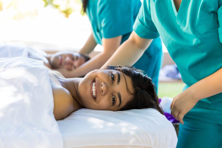 Smiling woman enjoying peaceful relaxing therapy with man at wellness salon